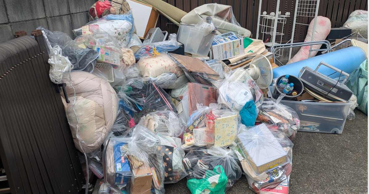 不用品回収で屋外に運び出された布団や衣類、生活雑貨など大量の不用品