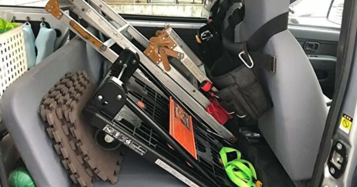 ハウスクリーニング車のセカンドシートに積んだ脚立や台車などの清掃道具