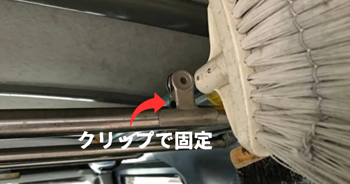 ハウスクリーニング車のシステムバー上で清掃道具をクリップ固定している様子